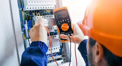 An electrician is using a tool to inspect the wires of an electrical panel in a Fair Grove, MO home.