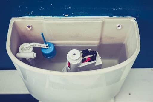 Open cistern of toilet, providing a downward look into the inside of the toilet tank in Springfield, MO.