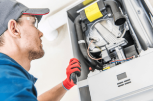 A technician examines a residential furnace in Springfield, MO.)