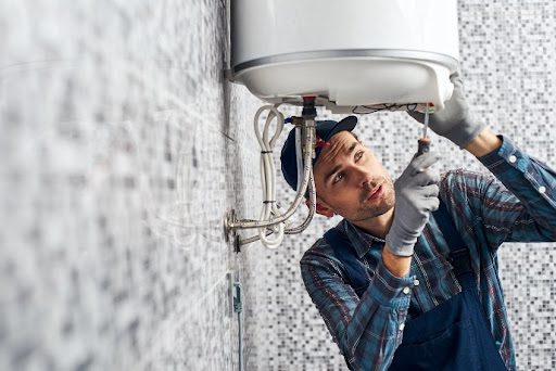 A professional technician performs repairs on a residential water heater in Springfield, MO.