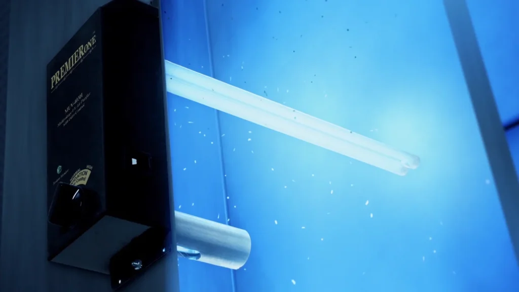 A close-up of an insect zapper machine activated, emitting blue light and surrounded by small flying insects—highlighting the importance of duct cleaning to help prevent pests indoors.